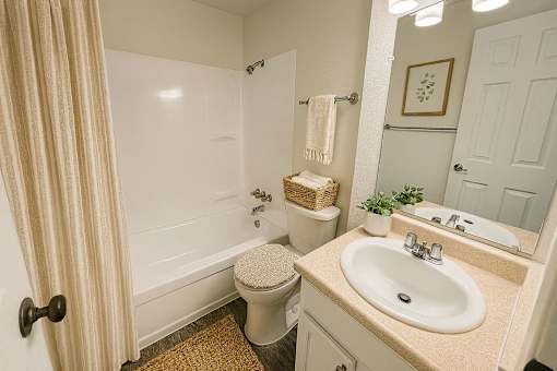 A bathroom with a toilet, sink, and shower.