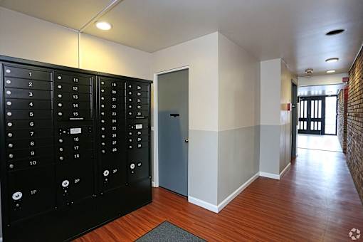 A hallway with a black door on the left and a blue door on the right.