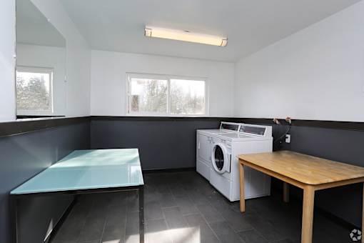 A laundry room with a washing machine and a table.