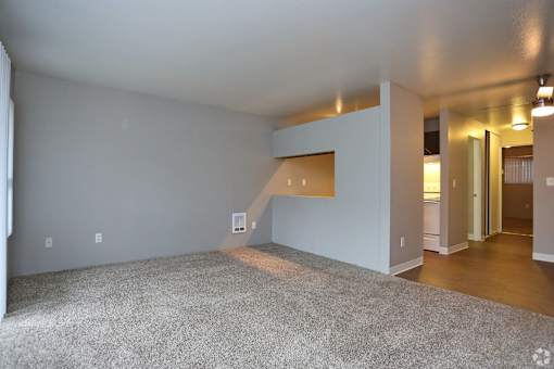 A room with a grey carpet and white walls.