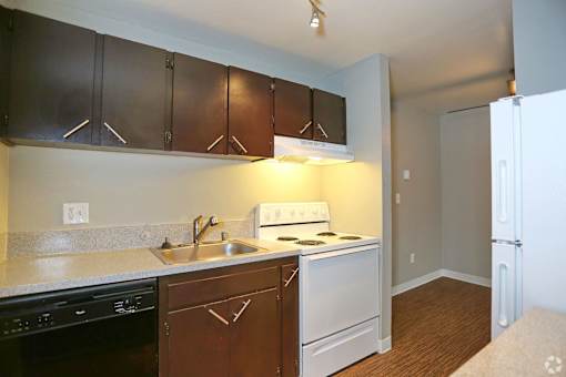 A kitchen with brown cabinets and white appliances.