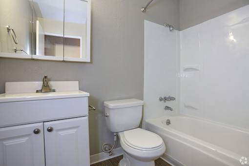 A white toilet sits next to a white sink in a bathroom.