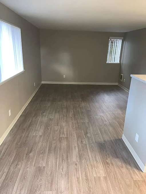 A room with wooden flooring and a window.
