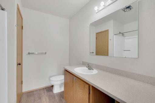 A small bathroom with a toilet, sink, and mirror.