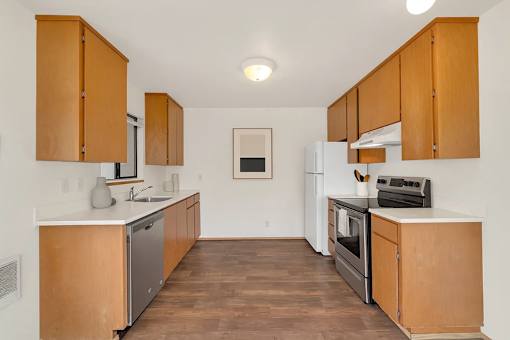 A kitchen with wooden cabinets and a white fridge.