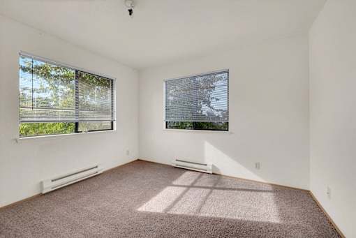 A room with a window and a wall-mounted air conditioner.