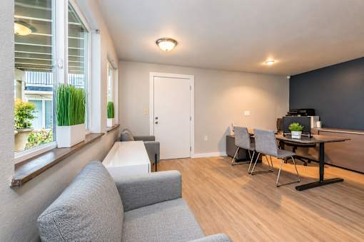 A living room with a grey couch, a black table, and a white door.