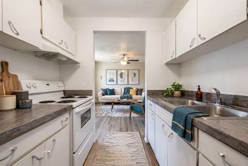 A kitchen with white cabinets and a rug on the floor.