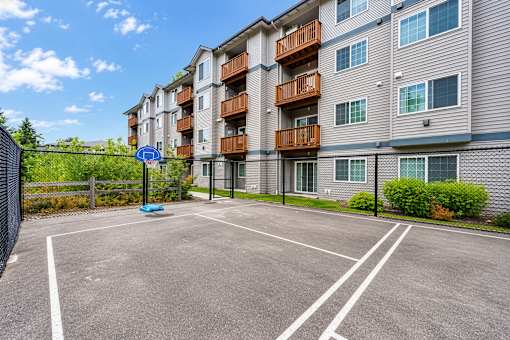 A parking lot in front of a residential building.