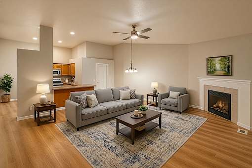 A living room with a grey couch, a coffee table, and a fireplace.