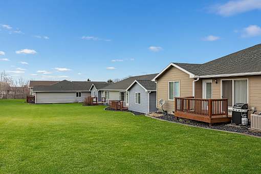 A row of houses with a green lawn in front.