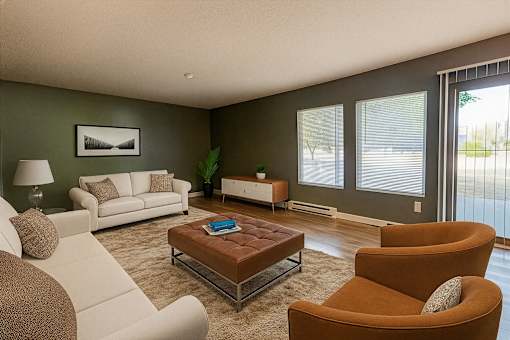 A living room with a white couch, a brown armchair, and a coffee table.