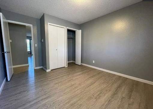 A room with a wooden floor and two white doors.