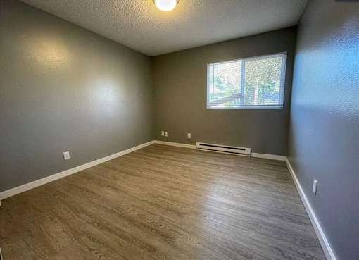 A room with wooden flooring and a window.