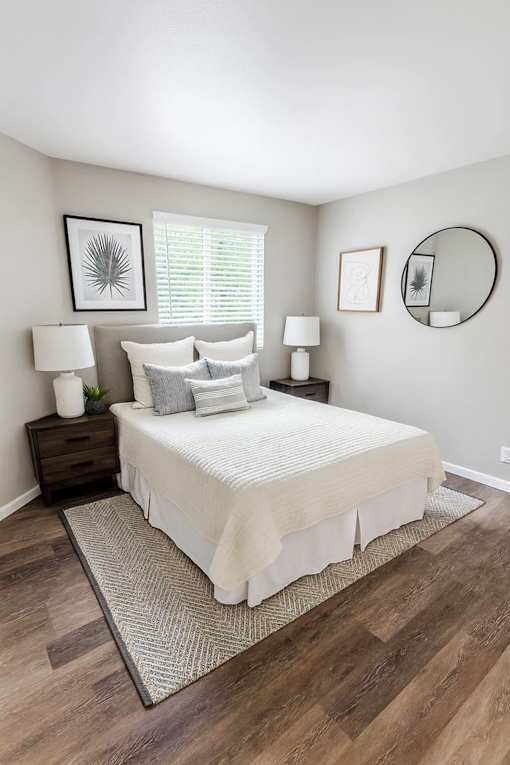 A bedroom with a bed, nightstands, and a rug.