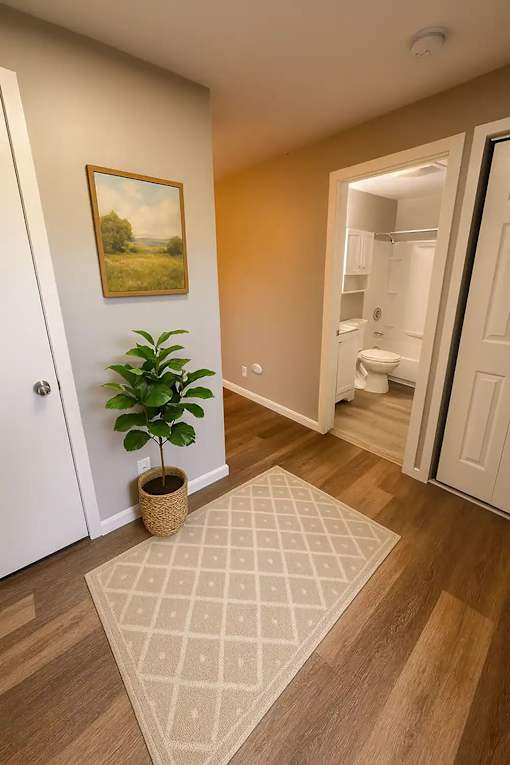 A room with a painting on the wall and a plant in a basket.