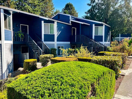 A blue house with a green lawn in front.