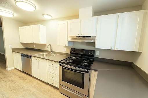 A kitchen with white cabinets and a black stove top oven.
