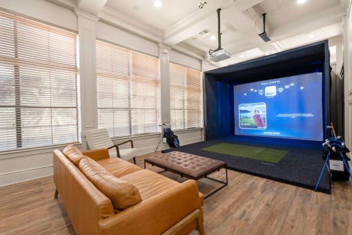 a living room with a projector screen and a couch