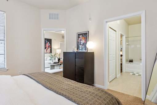 A bedroom with a large bed and a black cabinet.