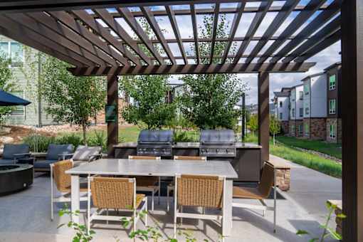 A patio with a table and chairs under a pergola.