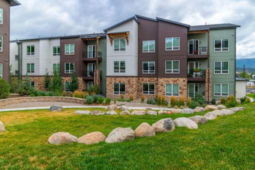 Apartment complex with a grassy area in front.