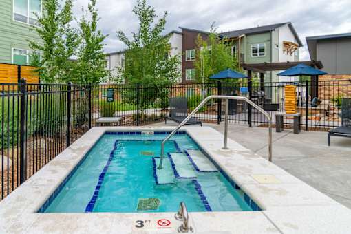 A small pool surrounded by a black fence with a sign that says 3 feet.