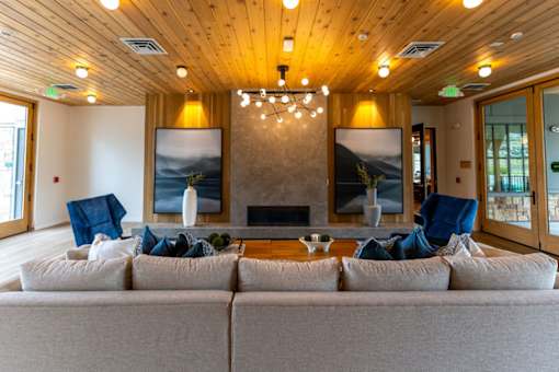 A living room with a grey couch and a fireplace.