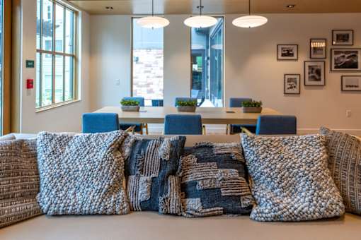 A room with a long table and a row of pillows on the floor.