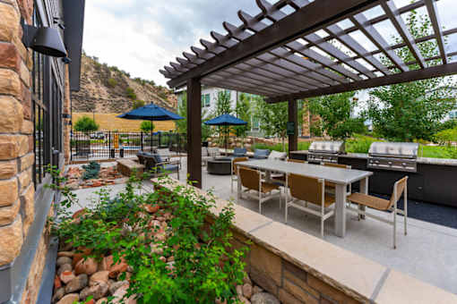 A patio with a table and chairs under a pergola.