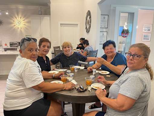 A group of people are sitting around a table eating food.