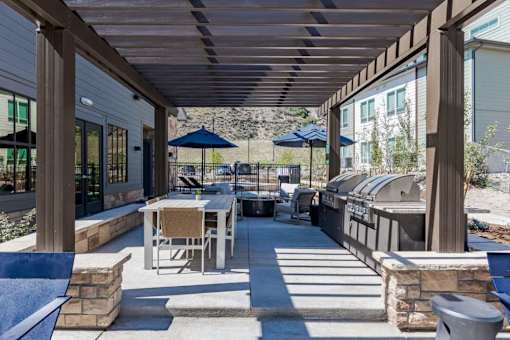 a covered patio with a grill and tables
