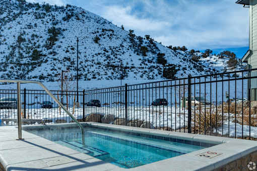 A pool surrounded by a fence with a mountain in the background.