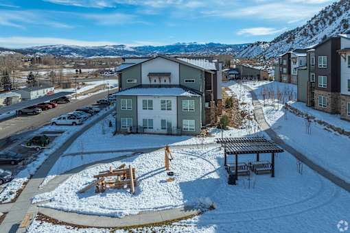 A snowy landscape with a building and a picnic table.