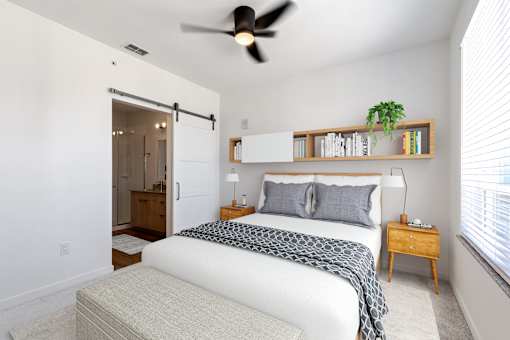 a bedroom with a bed and a ceiling fan