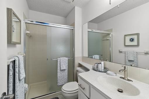 A bathroom with a toilet, sink, and shower.