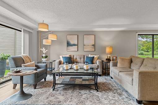 A living room with a sofa, armchair, and coffee table.