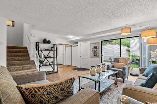 A living room with a brown couch and a glass table.