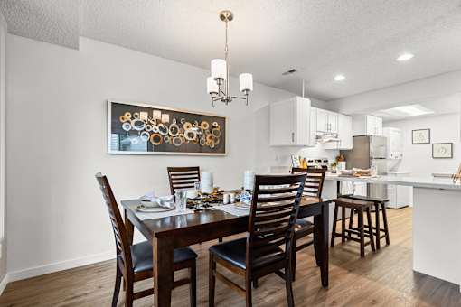 A dining room with a wooden table and chairs.