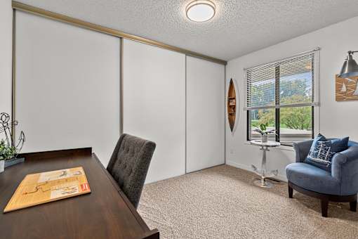 A room with a brown table and a grey chair.