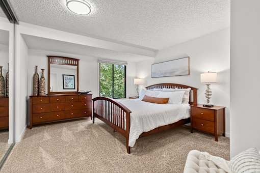 A bedroom with a large bed, a dresser, and a nightstand.