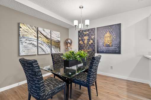 A dining room with a glass table and chairs.