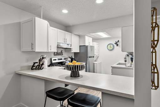 A kitchen with white cabinets and a white countertop.