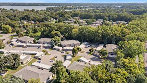 A bird's eye view of a residential area with houses surrounded by trees.