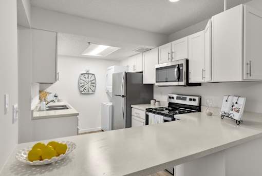 A kitchen with a bowl of lemons on the counter.