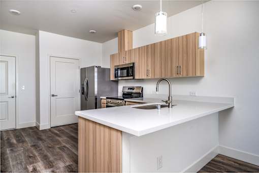 A kitchen with a white counter top and wooden cabinets.