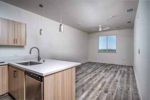 A kitchen with wooden cabinets and a stainless steel dishwasher.