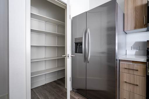 A modern kitchen with a stainless steel refrigerator and wooden cabinets.