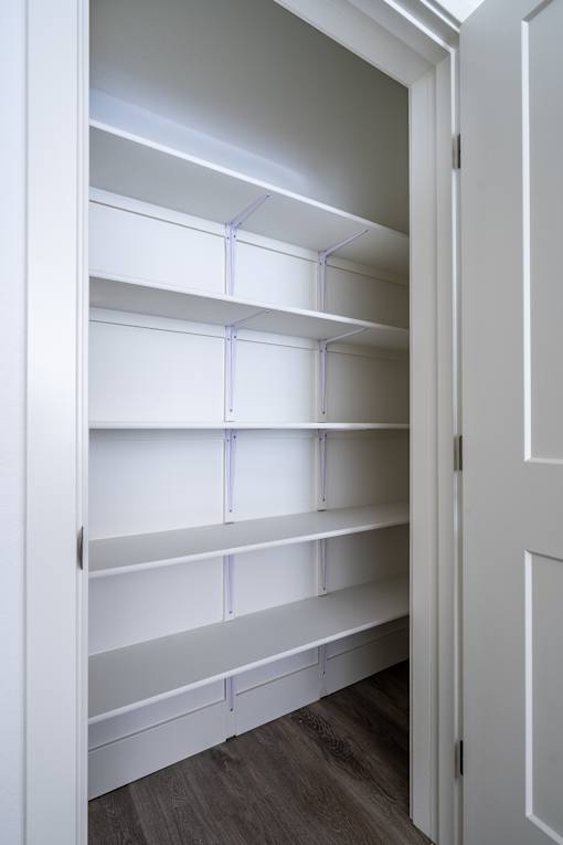Empty white shelves in a white closet.