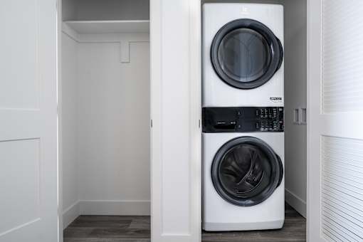 A white front load washing machine in a small laundry room.